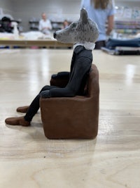 a figurine of a wolf sitting on a chair