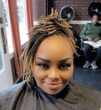 a woman with dreadlocks sitting in a salon