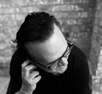 a black and white photo of a man with glasses