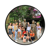 a group of people posing in front of a statue