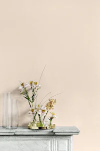 a vase of flowers sits on top of a mantle