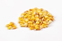 a pile of yellow corn on a white surface