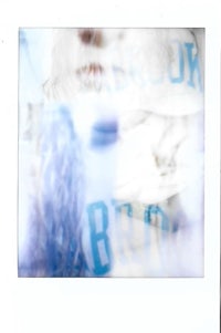 a polaroid photo of a woman in a blue shirt