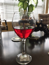 a glass of red wine on a table