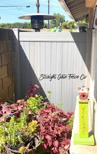 a fence with a potted plant in front of it
