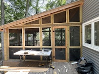 a wooden deck with a screened in porch