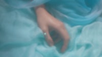 a woman's hand with a blue ring on it