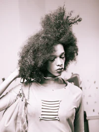 a black and white photo of a woman with an afro