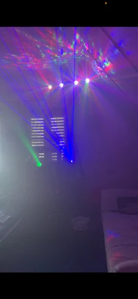 a room with colorful lights and a bed