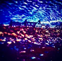 a photo of a house on a beach with a blue sky