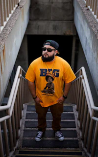 a man in a yellow t - shirt standing on stairs