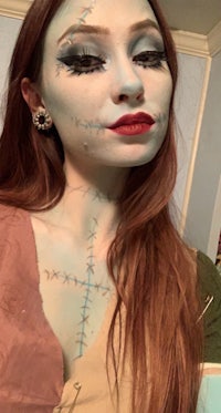 a woman dressed up as a skeleton with blue makeup