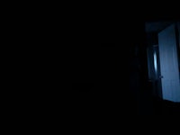 a dark room with a door open in the dark