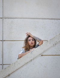 a woman leaning on a stair railing
