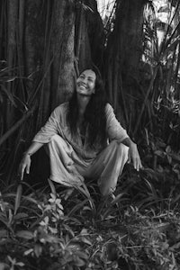 black and white photo of a woman sitting under a tree