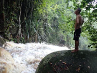 a man standing on a rock next to a river