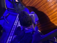 a man in a hat is playing a cello