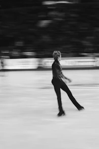 a black and white photo of a figure skater in motion