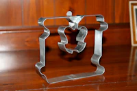 a metal cookie cutter sitting on a wooden table