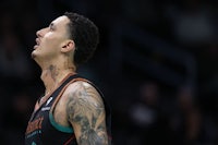a basketball player with tattoos looking up at the crowd
