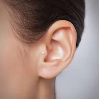 a woman's ear with a piercing