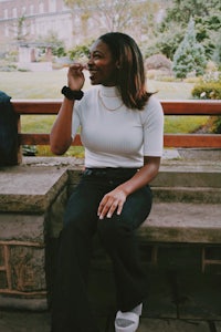 a woman is sitting on a bench in front of a building