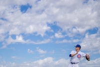 a baseball player throwing a ball in the sky