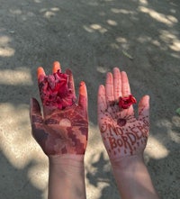 a woman's hands with red roses painted on them