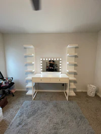 a room with a white vanity and a fan