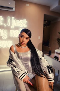 a woman in a silver jacket sitting in a chair