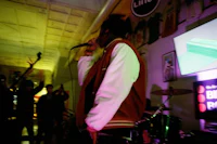 a man in a red jacket singing into a microphone