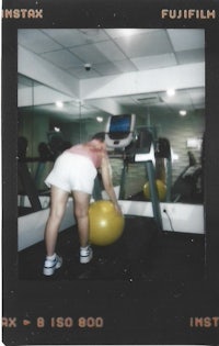 polaroid of a woman using an exercise ball in a gym