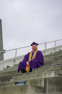 a man in a purple robe sitting on concrete steps