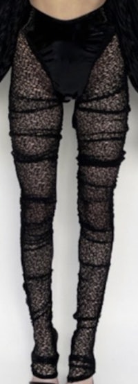 a woman wearing black tights and a black jacket