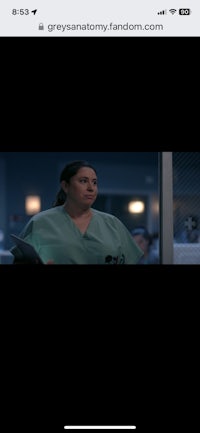 a woman in scrubs is standing in front of a window