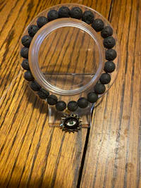 a black lava stone bracelet on a wooden table