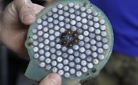 a person is holding a piece of plastic with a lot of holes in it
