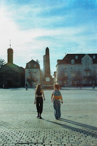 two people walking in a city square