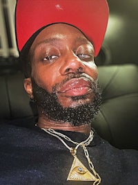 a man wearing a red hat and a necklace