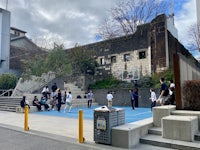 a group of people on a basketball court in front of a building