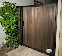 a wooden gate with a plant in front of it