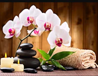 a spa room with candles and orchids on a wooden table