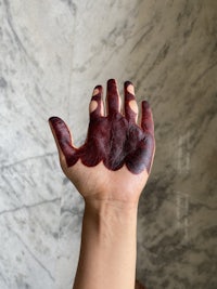 a person's hand with red paint on it