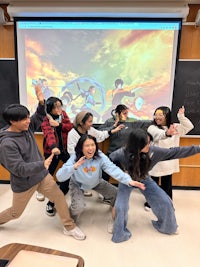 a group of students posing in front of a projector