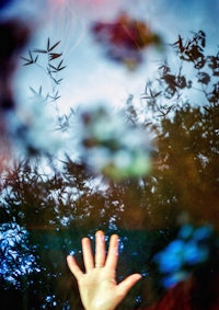 a person's hand is reflected in a glass of water