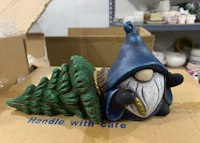 a figurine of a gnome next to a tree