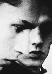 a black and white photo of two men looking at each other