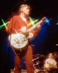 a man playing an electric guitar on stage