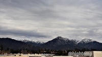 a cloudy sky with mountains in the background