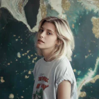 a blonde woman in a t - shirt standing in front of a map